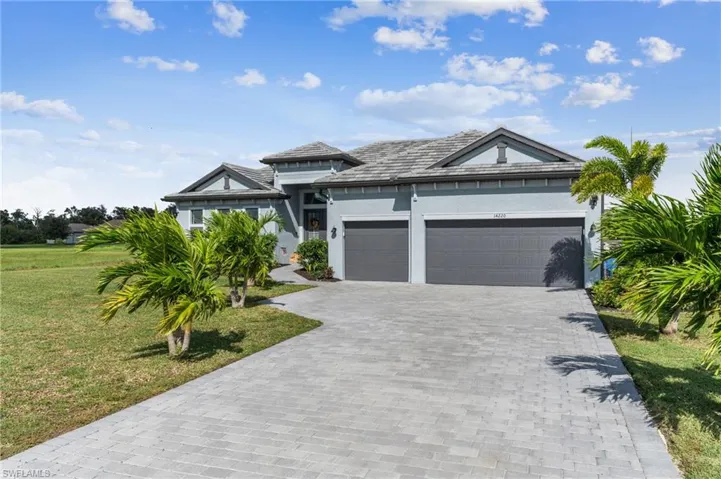 View of front of home with a garage and a front lawn