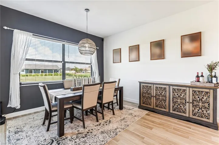 Dining area with light hardwood / wood-style floors and a notable chandelier