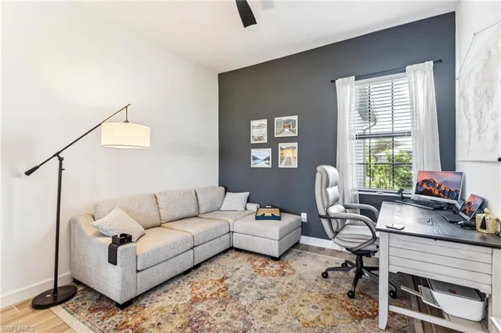 Home office with hardwood / wood-style floors and ceiling fan