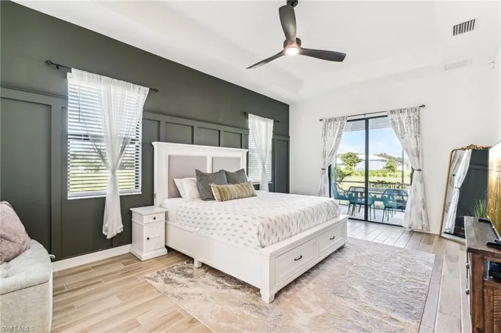 Bedroom with ceiling fan, light wood-type flooring, and access to outside