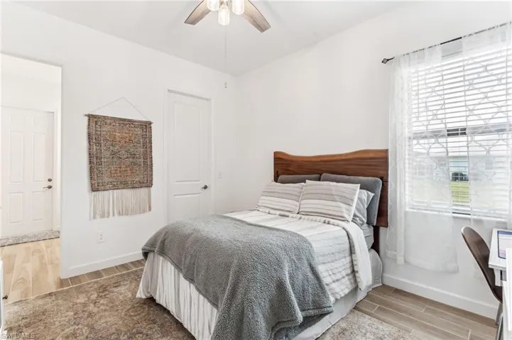 Bedroom with light hardwood / wood-style floors and ceiling fan