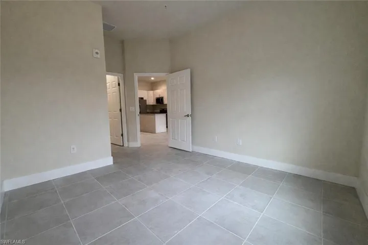 Unfurnished room featuring light tile patterned floors and a towering ceiling