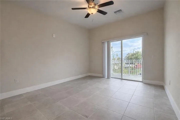 Empty room featuring a ceiling fan and light tile patterned flooring