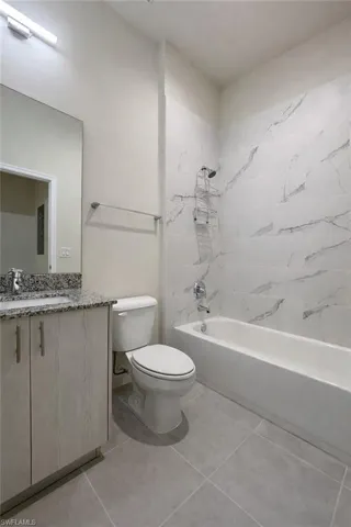 Full bathroom with shower / washtub combination, vanity, and light tile patterned flooring