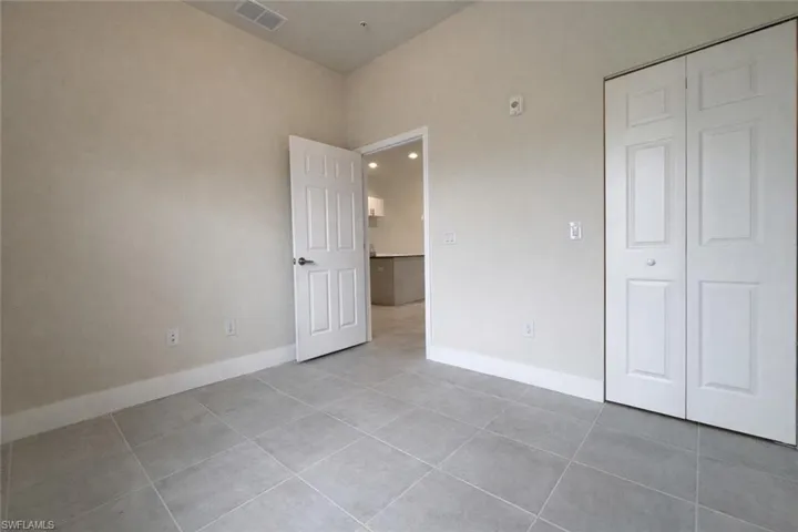 Unfurnished bedroom with a closet and light tile patterned floors