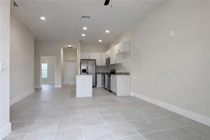 Kitchen featuring a center island, stainless steel appliances, recessed lighting, open floor plan, and a ceiling fan