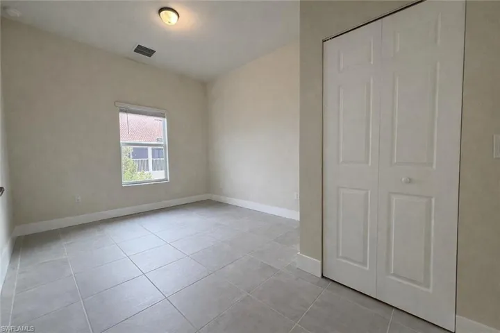 Unfurnished bedroom with light tile patterned flooring and a closet