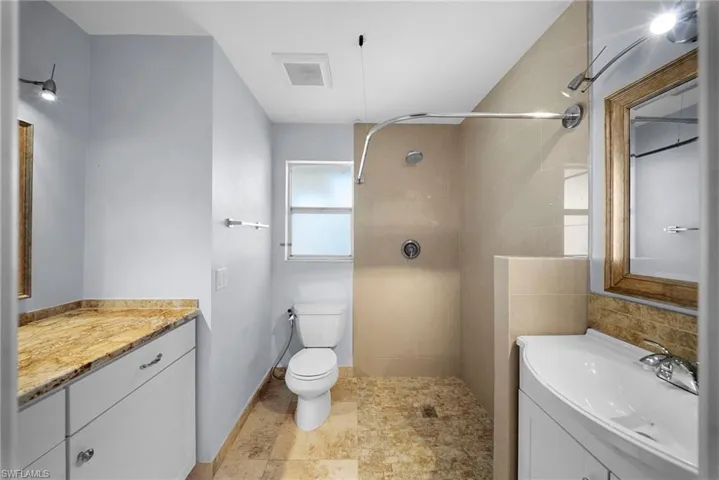 Walk-in shower with light-toned tile, floor-to-ceiling