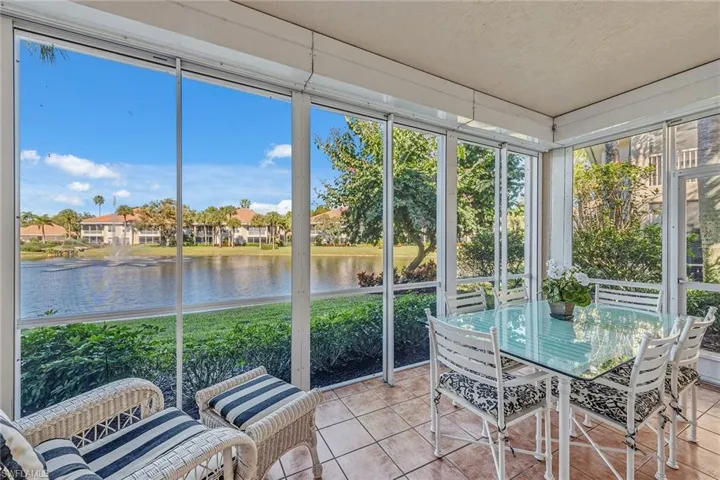 Sunroom featuring a water view, tile patterned floors, healthy amount of natural light, and a textured ceiling