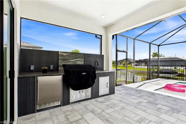 FULLY EQUIPED OUTDOOR KITCHEN w/ BUILT-IN stainless steel BBQ GRILL, SINK, BEVERAGE REFRIGERATOR, GRANITE COUNTERTOPS & MODERN BACKSPLASH!