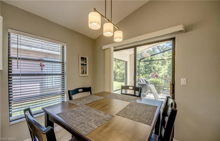 Dining space with vaulted ceiling and view of preserves out back