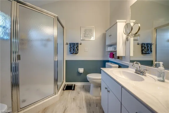 Updated Primary Bathroom featuring matching floors and large shower enclosure