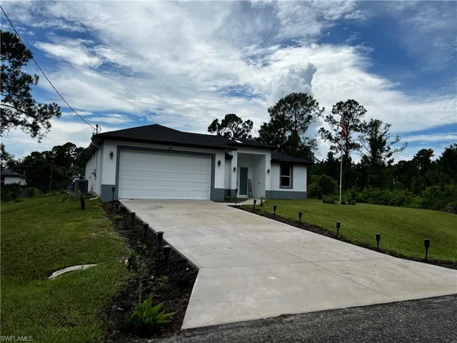 Single story home with stucco siding, driveway, cooling unit, an attached garage, and a front yard