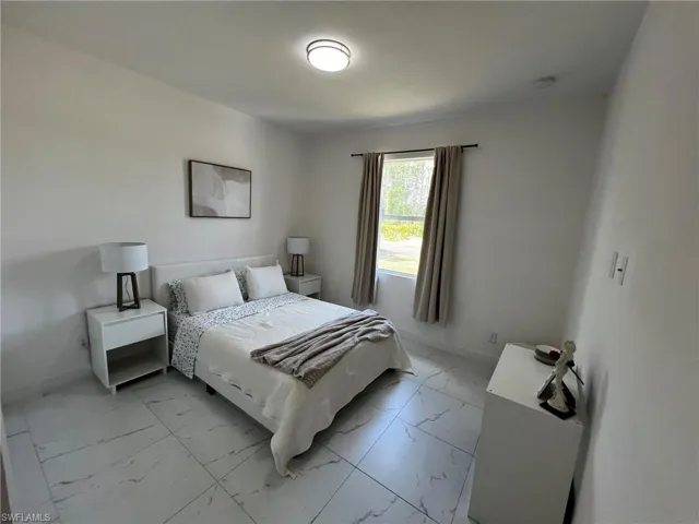 Bedroom with marble finish floor and baseboards