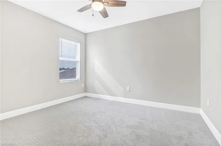 Empty room featuring carpet floors and a ceiling fan