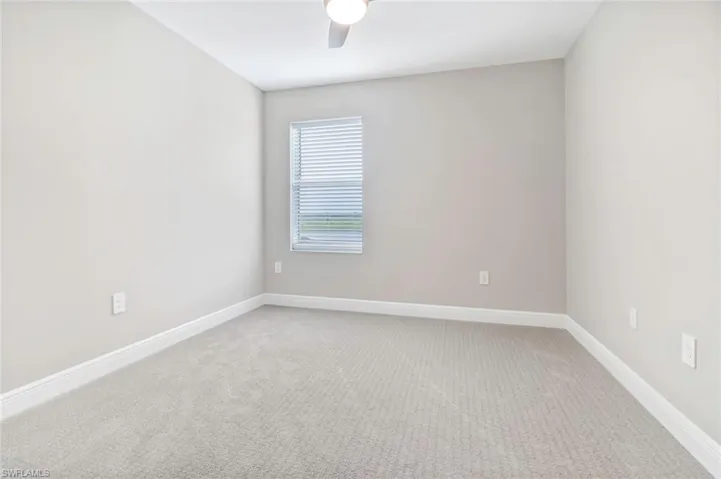 Empty room with light carpet and a ceiling fan