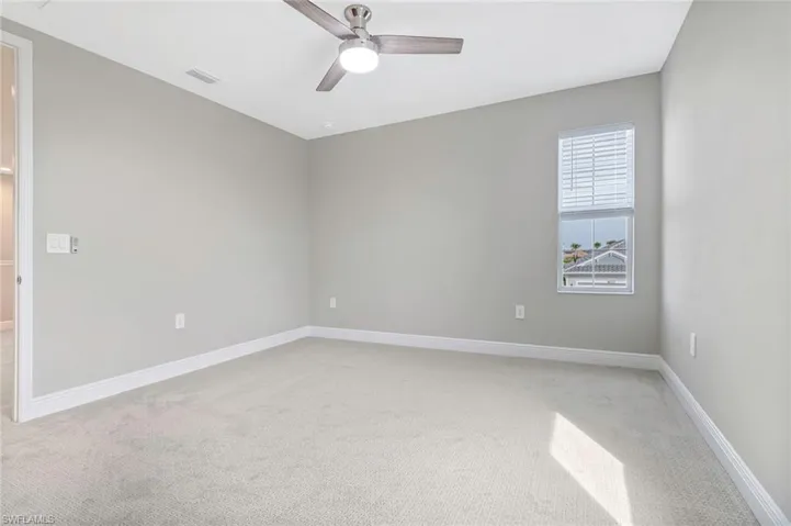 Spare room featuring light carpet and a ceiling fan