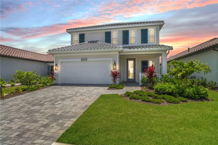 Mediterranean / spanish-style house with a tiled roof, decorative driveway, a garage, and a porch