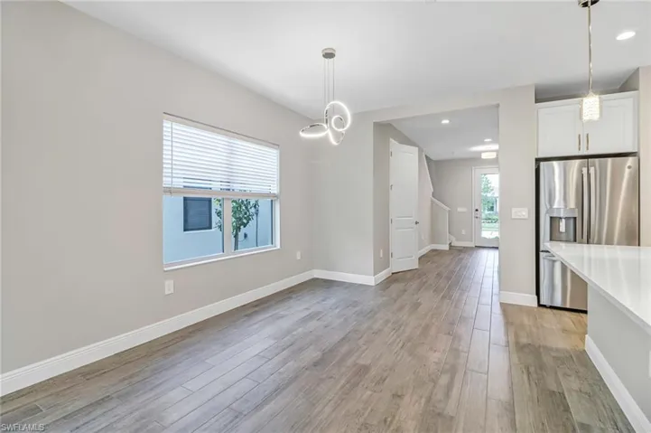Unfurnished dining area featuring light wood-style floors and baseboards