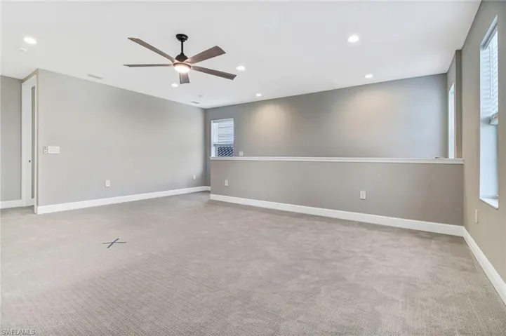 Empty room with a ceiling fan, recessed lighting, and light carpet