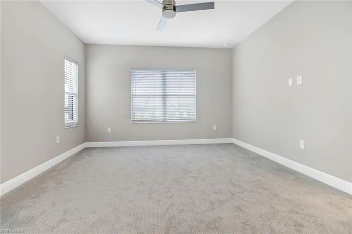 Spare room featuring ceiling fan and light colored carpet
