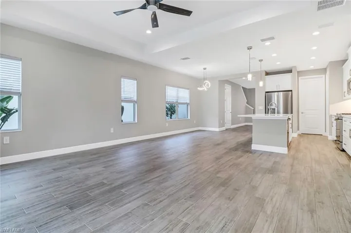 Unfurnished living room with ceiling fan, recessed lighting, and light wood finished floors