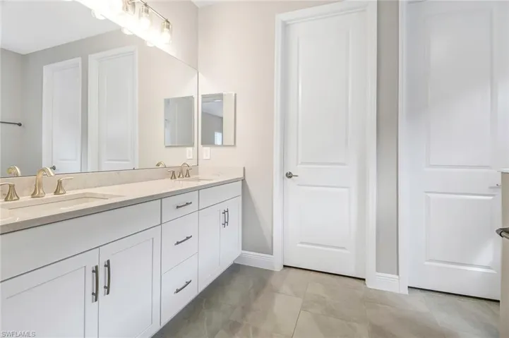Bathroom featuring double vanity and light tile patterned floors