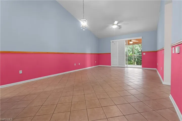 Great room featuring tile flooring, vaulted ceilings, and a sliding glass door opening to a private balcony
