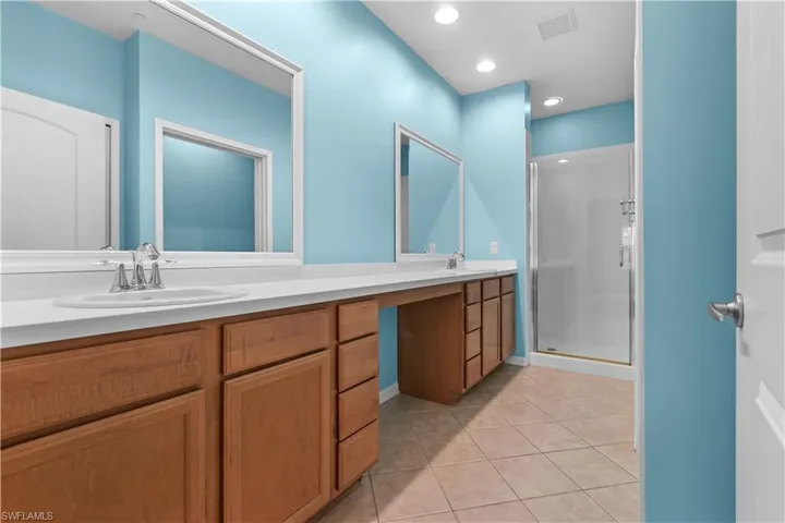 Spacious primary bathroom featuring double sinks and a walk-in shower
