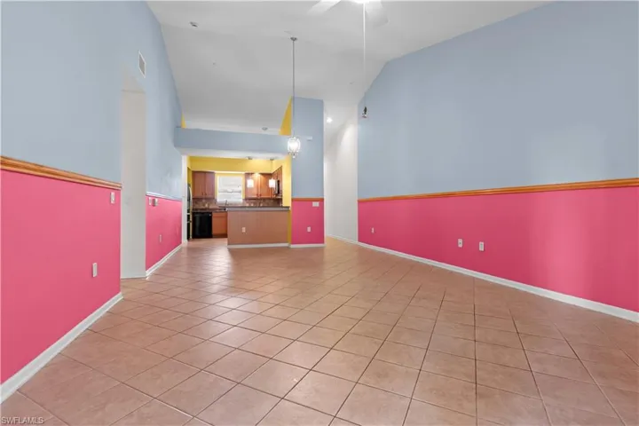 Open-concept living area with vaulted ceilings, tile flooring, and a dining space