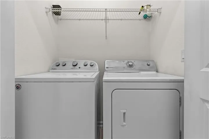 Dedicated laundry area featuring a white top-load washing machine and a white front-load dryer