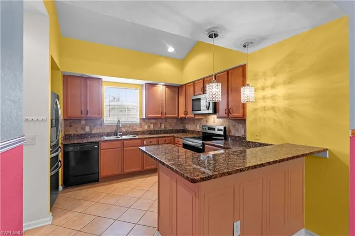 Kitchen featuring wood cabinetry, granite countertops, and a full tile backsplash