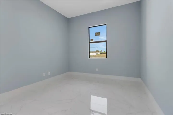 Spare room featuring baseboards and marble finish floor