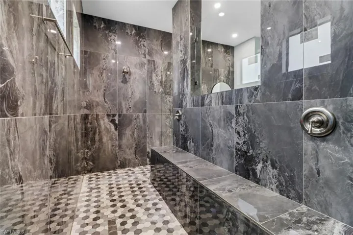 Bathroom with a walk in shower and tile walls