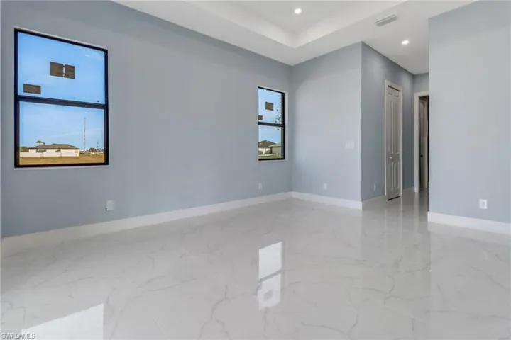 Spare room featuring visible vents, a healthy amount of sunlight, and marble finish floor