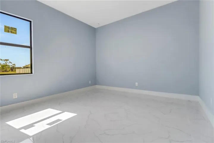 Unfurnished room featuring baseboards and marble finish floor