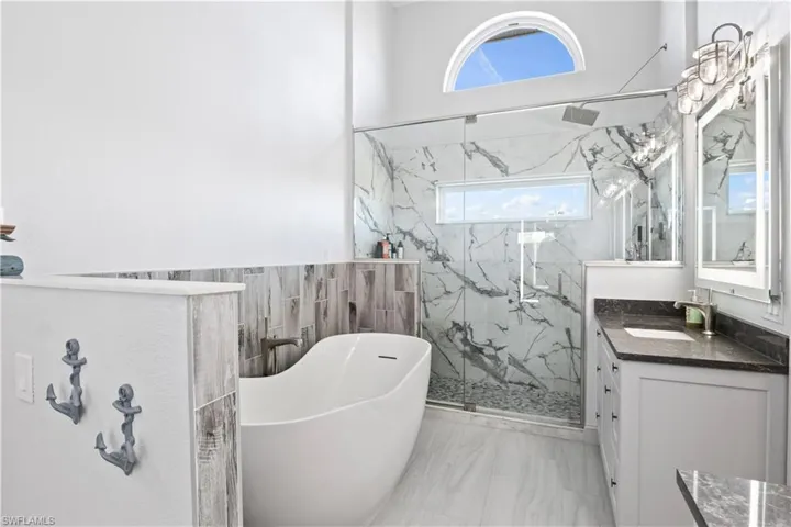 Primary en suite bathroom with HUGE walk in shower and soaking tub. So many lovely details here.