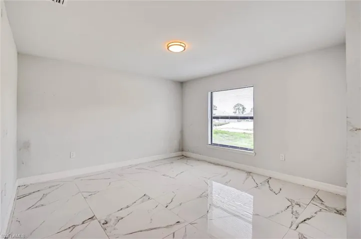 Neutral wall tones complement the polished tile flooring throughout this room