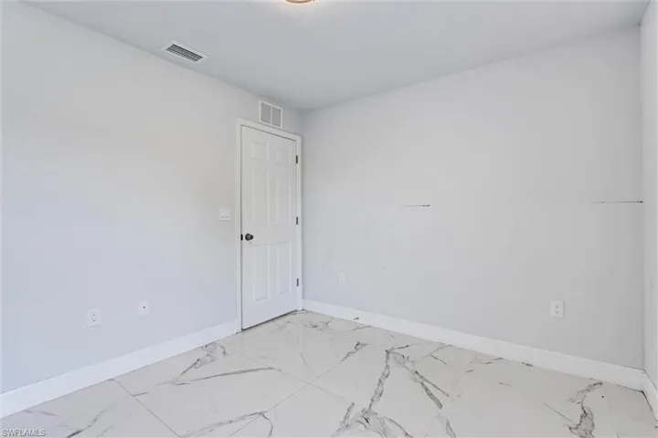 Light-filled room featuring large format tile flooring with a striking veined pattern