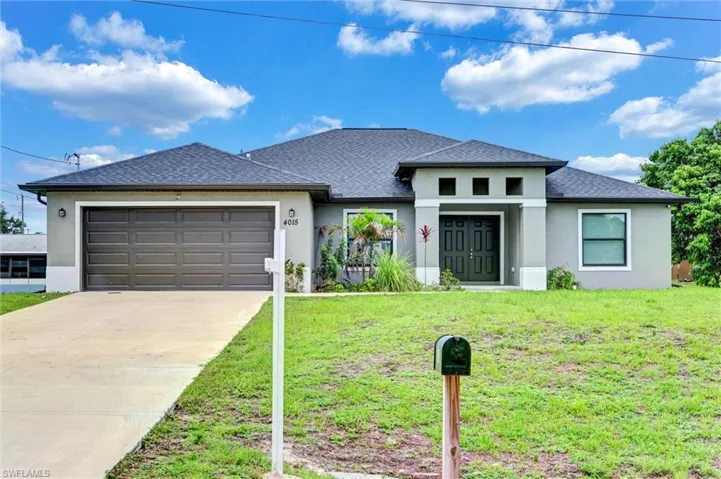 Contemporary single-story residence featuring a gray stucco exterior, dark asphalt shingle roof, a two-car garage with a brown panel door, and a prominent double-door entry with decorative transom windows