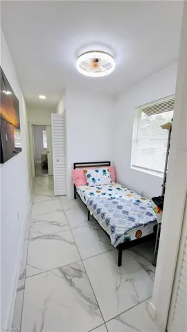 Bedroom with light marble finish floors and baseboards