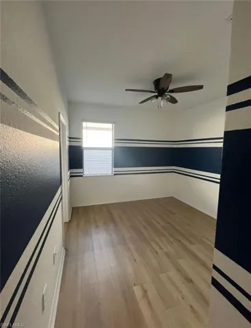 Unfurnished room with light wood-type flooring and a ceiling fan