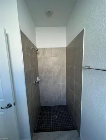 Bathroom featuring a stall shower and a textured wall
