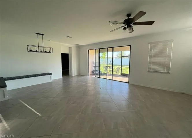 Unfurnished room with dark tile patterned floors and ceiling fan