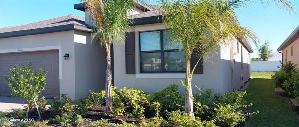 View of property exterior featuring an attached garage, stucco siding, and a shingled roof