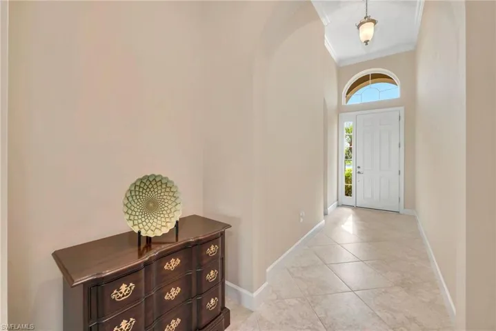 Tiled entrance foyer featuring a high ceiling and ornamental molding