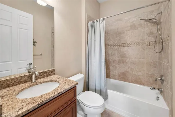 Full bathroom with shower / bath combo, vanity, and toilet