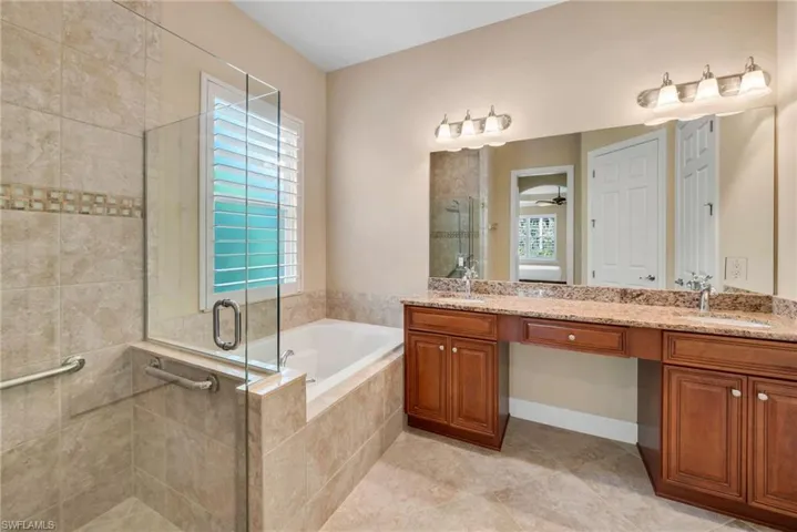 Bathroom featuring tile patterned floors, ceiling fan, vanity, and separate shower and tub