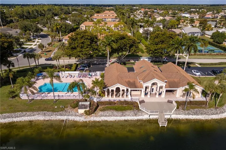 Aerial perspective of suburban area with a pool and a large body of water