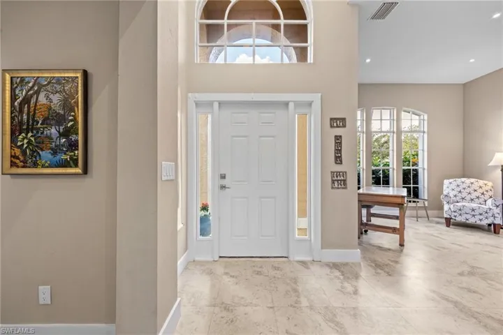 Entryway with baseboards and a towering ceiling